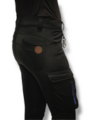 Seitenansicht des oberer Teils der Winterreithose Damen, mit Eskotomic Logo auf der Gesäßtasche aus braunem Leder, Haken am Gürtelband und großer Tasche auf dem Oberschenkel mit blauem wasserdichtem Reißerschluss. Man erkennt den Grippbesatz und den Softshellstoff, die Reithose ist eine Mischung aus Jodpurhose und Stiefelhose, perfekt zum Arbeiten und Reiter.